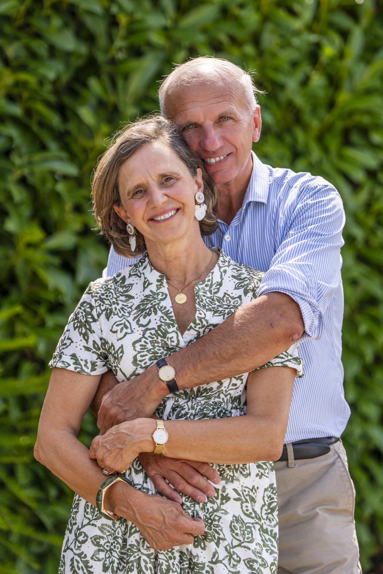 Couple enlacé devant un jardin verdoyant