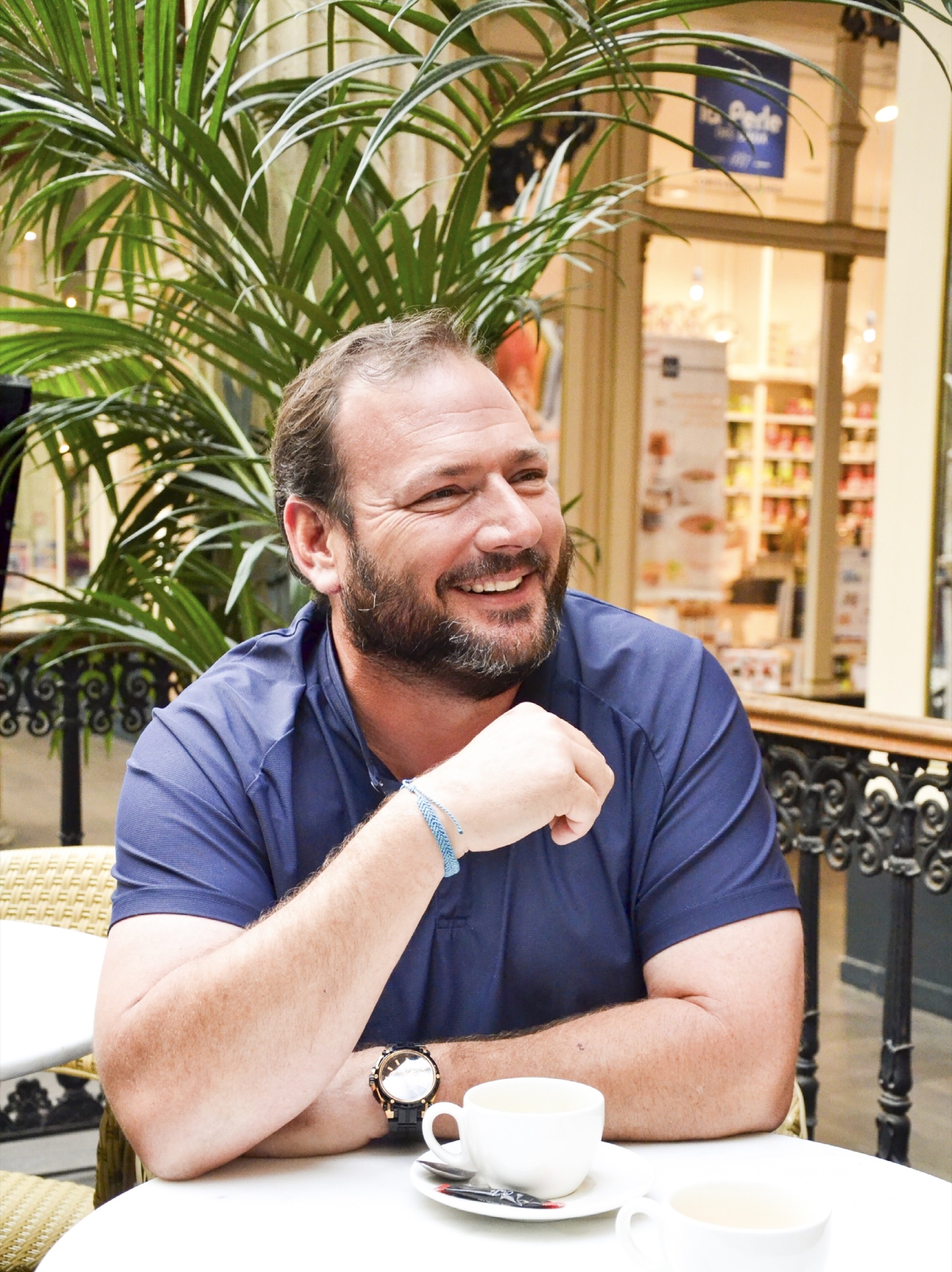 Portrait naturel d’un homme souriant à la terrasse d’un café
